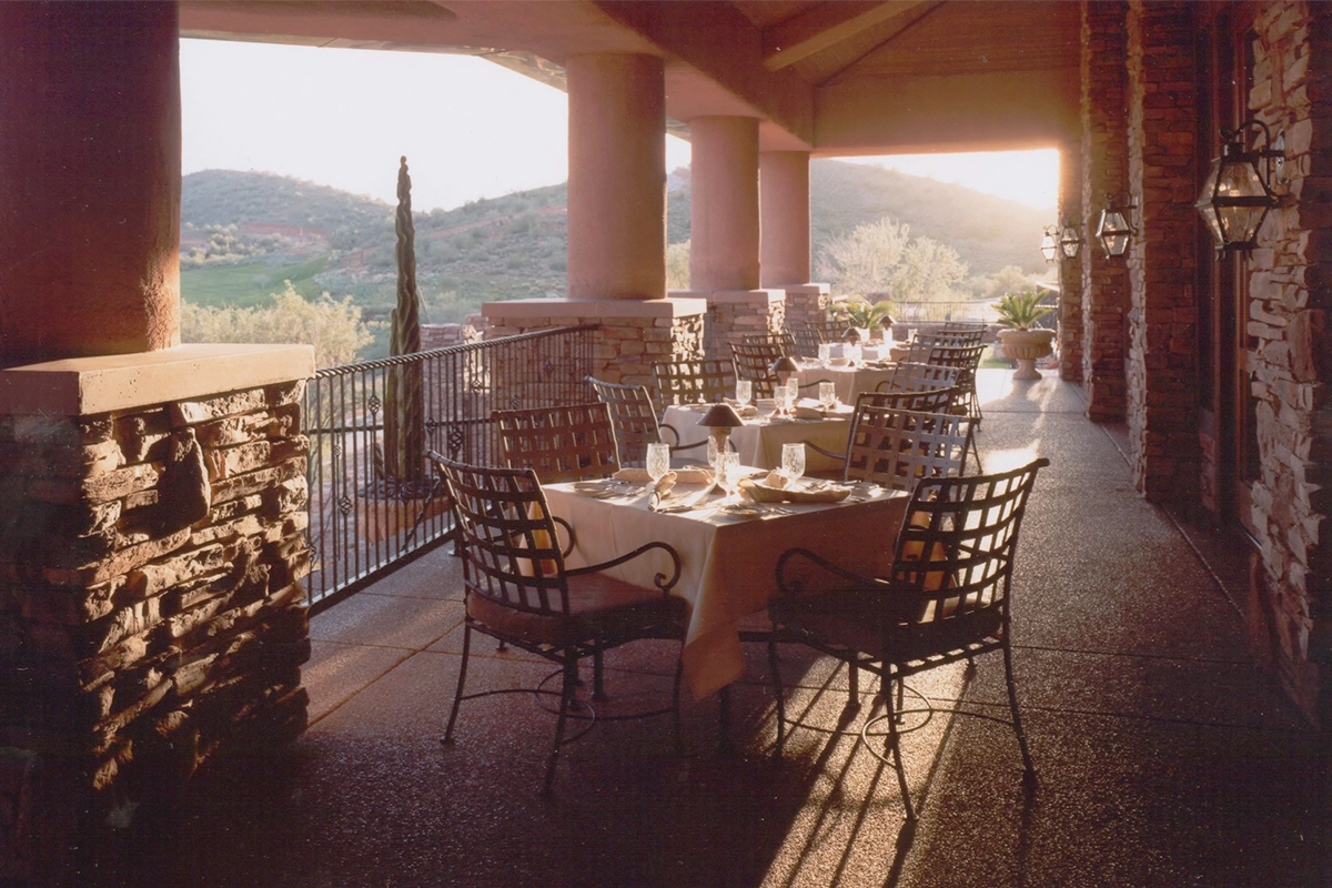 Fire Rock Country Club covered outdoor dining terrace with mountain views and wrought iron furniture overlooking golf course at sunset