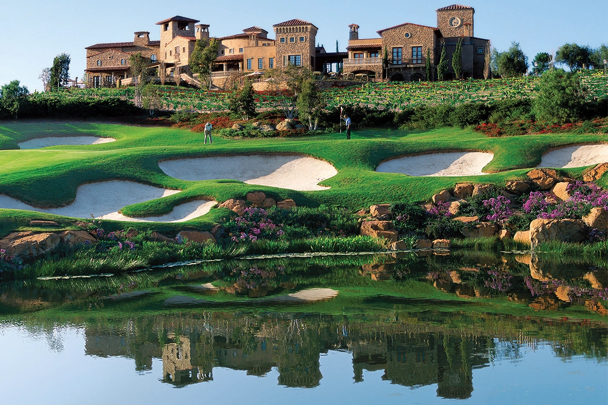 Championship golf course at The Bridges at Rancho Santa Fe featuring water hazards, sand bunkers and Tuscan-style clubhouse overlooking vineyard