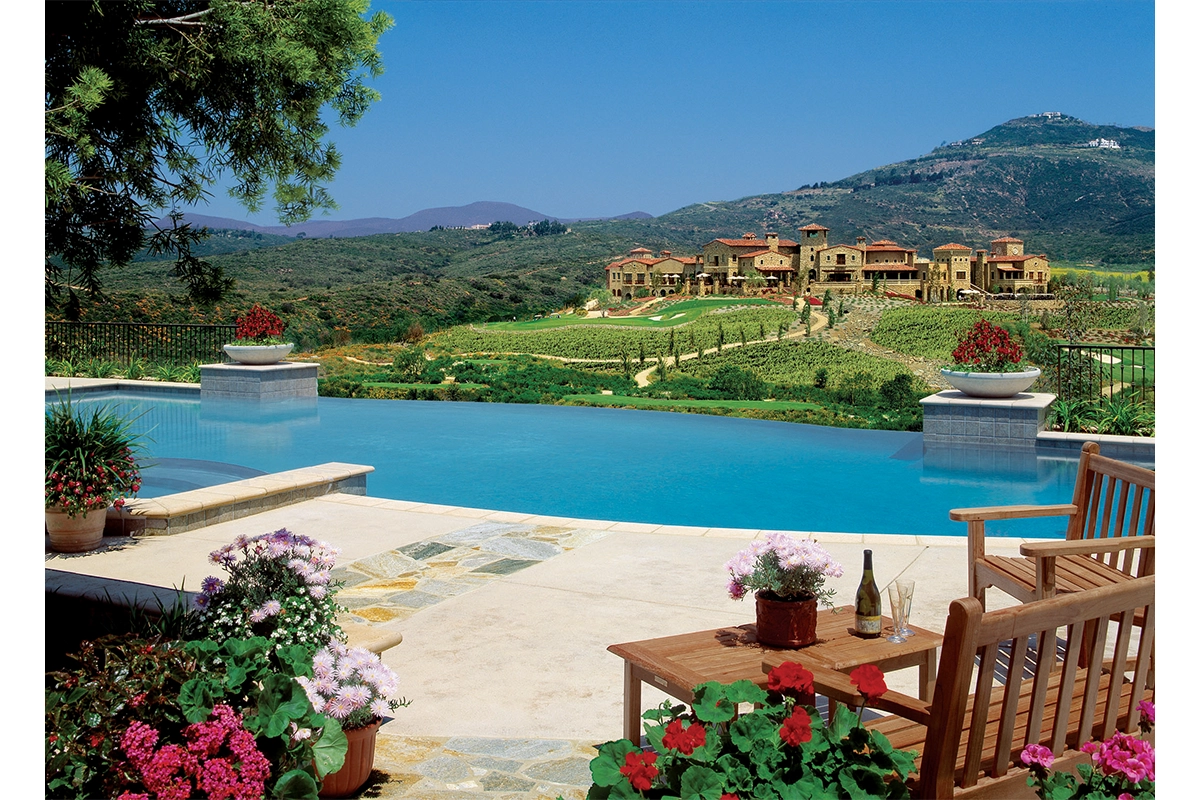 Infinity edge pool at The Bridges at Rancho Santa Fe overlooking rolling vineyards and mountain vistas with outdoor entertaining area