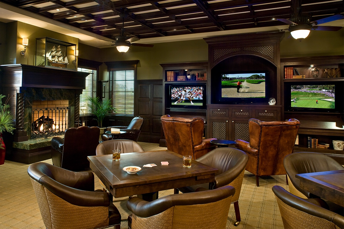 Luxury Conservatory Club lounge with leather seating, coffered ceiling, and fireplace, at Hammock Beach Resort